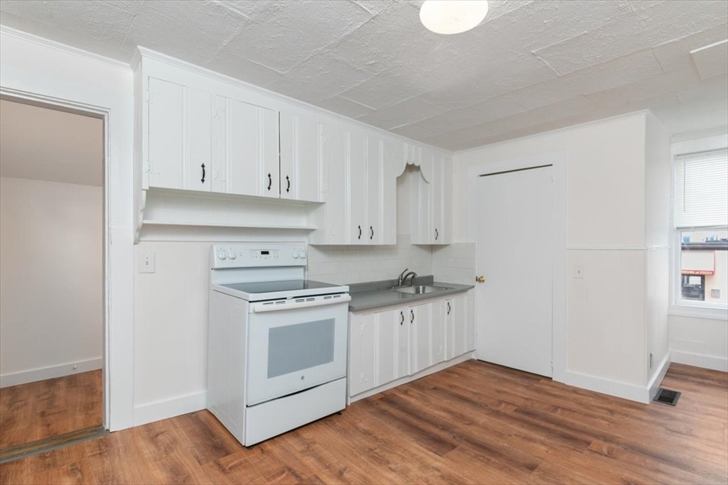 7 Cox Court Beverly, MA 01915 - Photo 6 of 23 a kitchen with granite countertop a stove and white cabinets