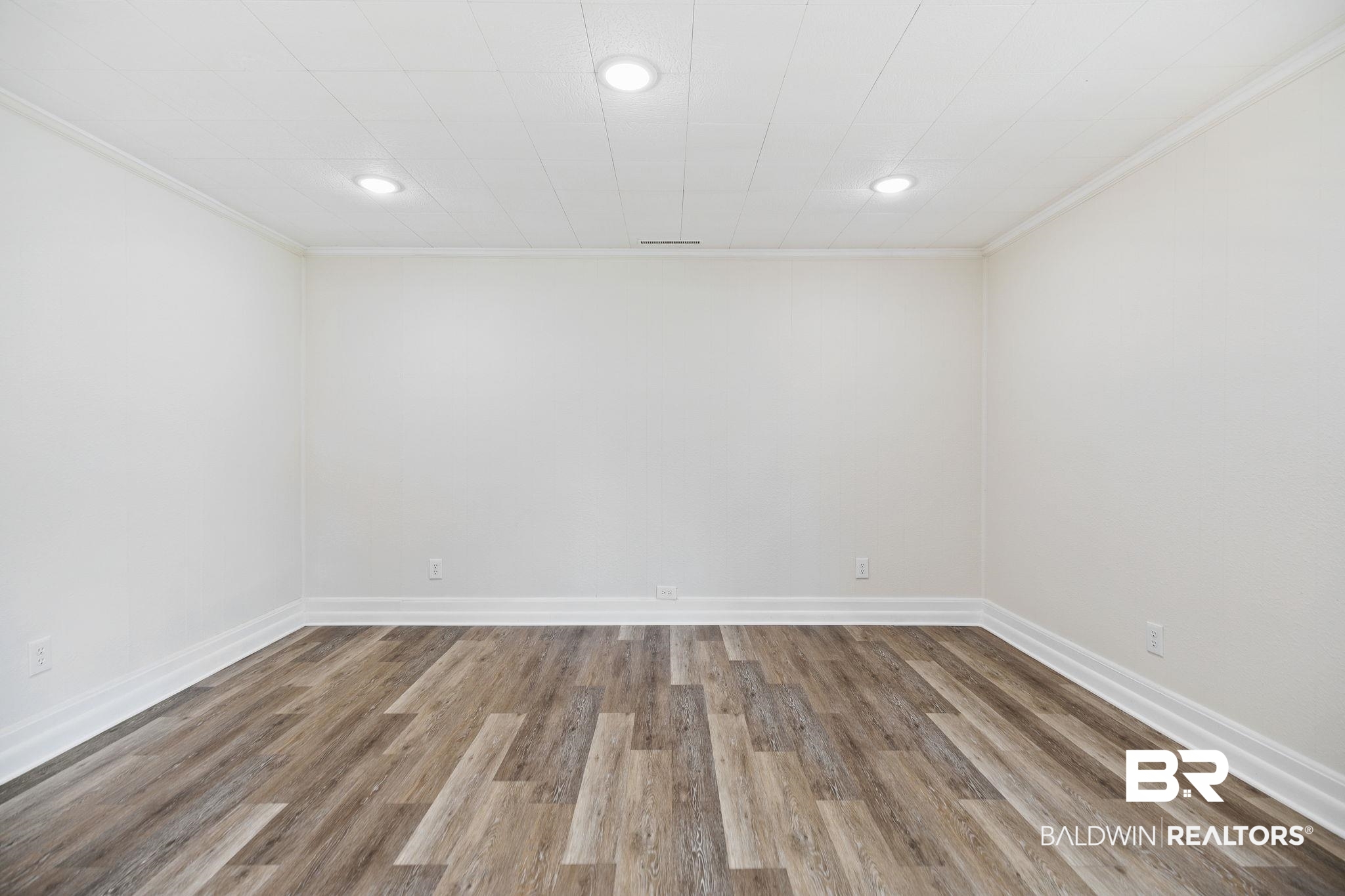 507 Byrne Street Bay Minette, AL 36507 - Photo 23 of 40 Spare room featuring wood-type flooring and ornamental molding