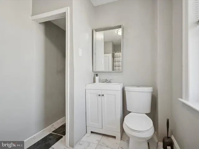 a bathroom with a toilet a sink and mirror