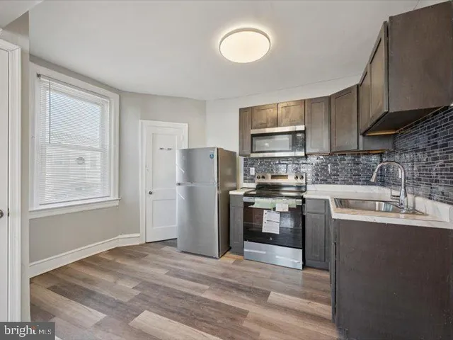a kitchen with granite countertop a refrigerator stove and sink