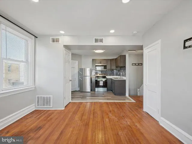 a view of a kitchen with wooden floor and a window