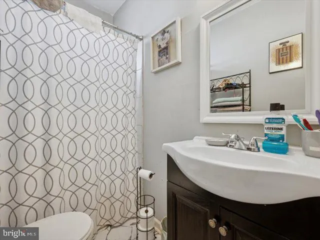 a bathroom with a sink a toilet and a mirror