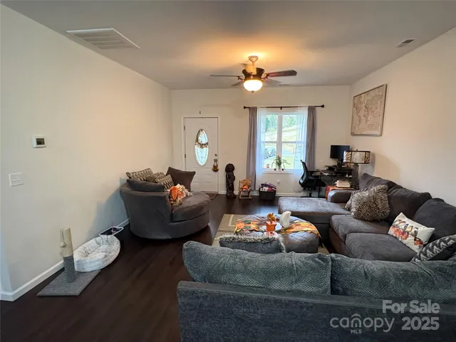 a living room with furniture and wooden floor