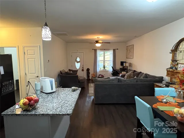 a living room with furniture kitchen view and a chandelier