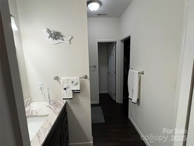 a en suite bathroom with a granite countertop sink