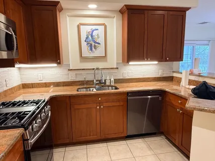 a kitchen with kitchen island granite countertop a sink and a stove