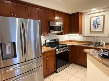 a kitchen with granite countertop stainless steel appliances and wooden cabinets