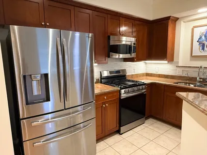 a kitchen with stainless steel appliances granite countertop a refrigerator stove and microwave