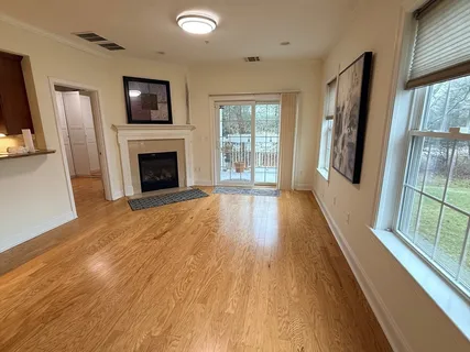 a view of a livingroom with wooden floor and a fireplace