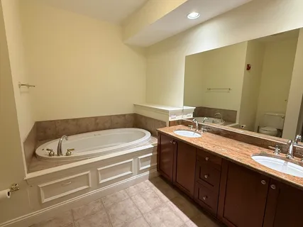 a bathroom with a tub sink and mirror
