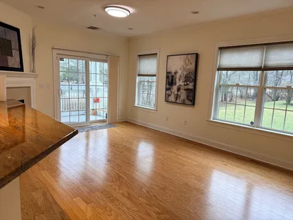 a view of an empty room with window and wooden floor
