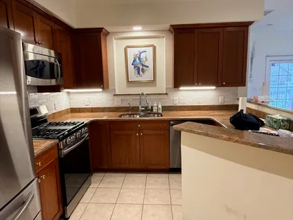 a kitchen with a sink stove top oven and cabinets