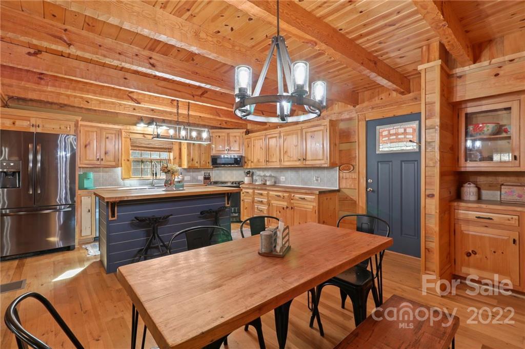 431 Silas Creek Road, Unit 4 Lansing, NC 28643 - Photo 11 of 46 a kitchen with a table chairs refrigerator and cabinets