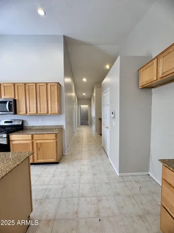 a kitchen with stainless steel appliances granite countertop a stove a sink and a refrigerator