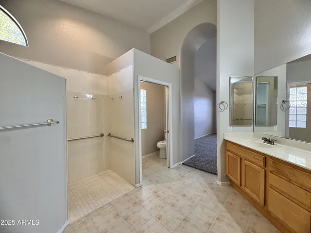 a spacious bathroom with a shower sink and mirror