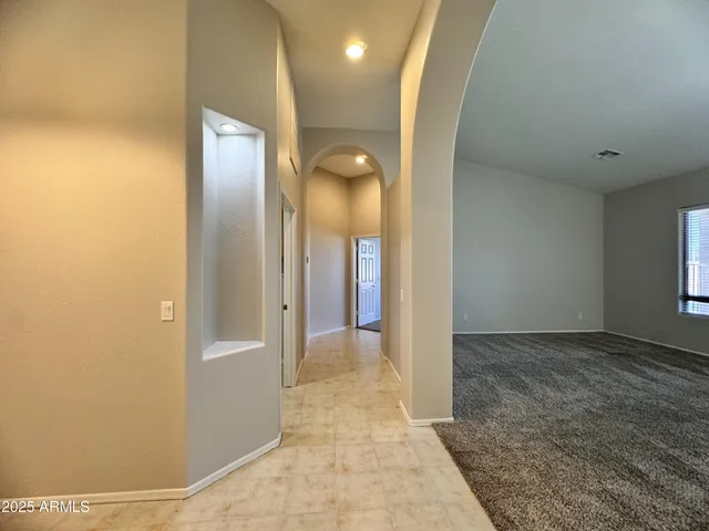 a view of an empty room with window and cabinet