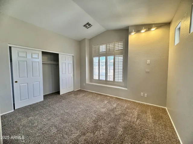 a view of a room with a hanging light and kitchen