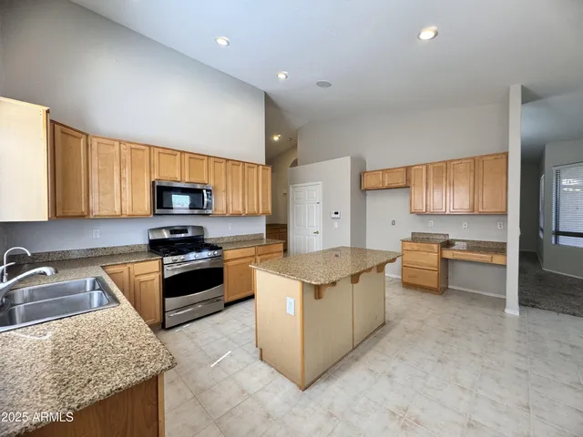 a kitchen with stainless steel appliances granite countertop a sink stove and refrigerator