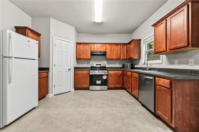 a kitchen with stainless steel appliances granite countertop a refrigerator sink and cabinets