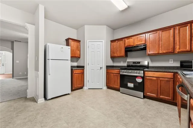 a kitchen with stainless steel appliances a refrigerator sink and cabinets
