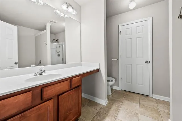 a spacious bathroom with a granite countertop sink a toilet and a mirror