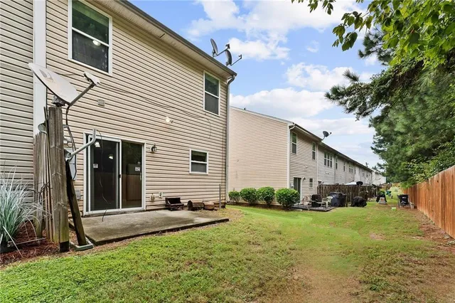 a front view of a house with a yard and potted plants