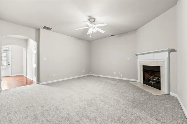 an empty room with fireplace and fan