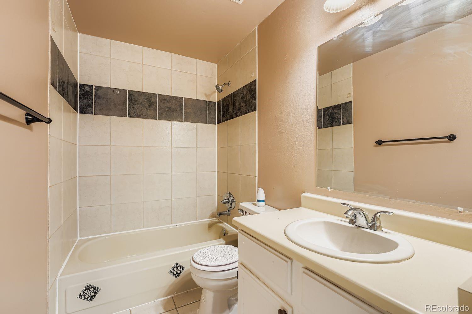 17365 East Rice Circle, Unit A Aurora, CO 80015 - Photo 11 of 18 a bathroom with a sink a toilet and shower