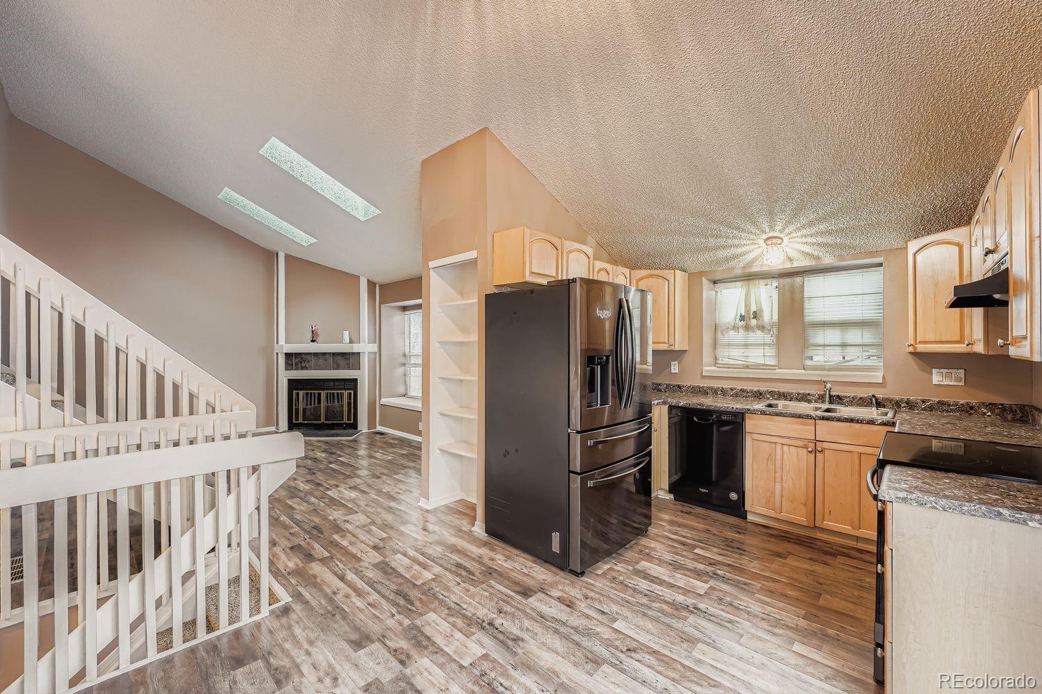 17365 East Rice Circle, Unit A Aurora, CO 80015 - Photo 4 of 18 a kitchen with granite countertop a refrigerator and a stove top oven