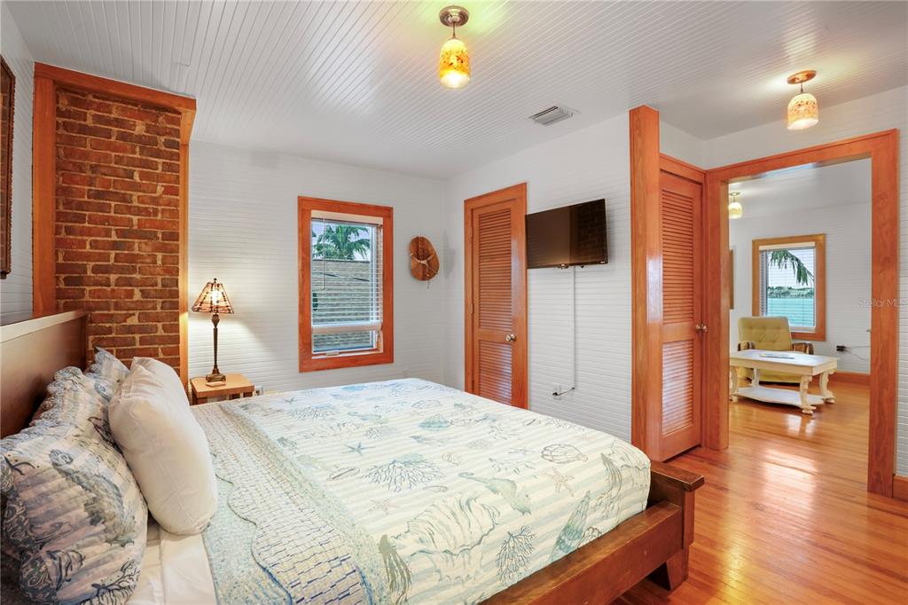 702 Pass A Grille Way St. Pete Beach, FL 33706 - Photo 20 of 41 a bedroom with a bed and a flat tv screen on dresser