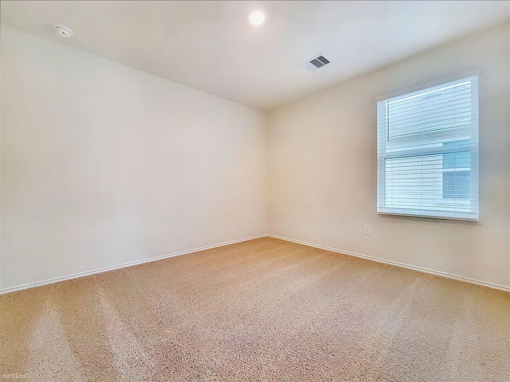419 Sickle Loop Kyle, TX 78640 - Photo 28 of 35 A well-lit room offers fresh carpet and ample natural light.
