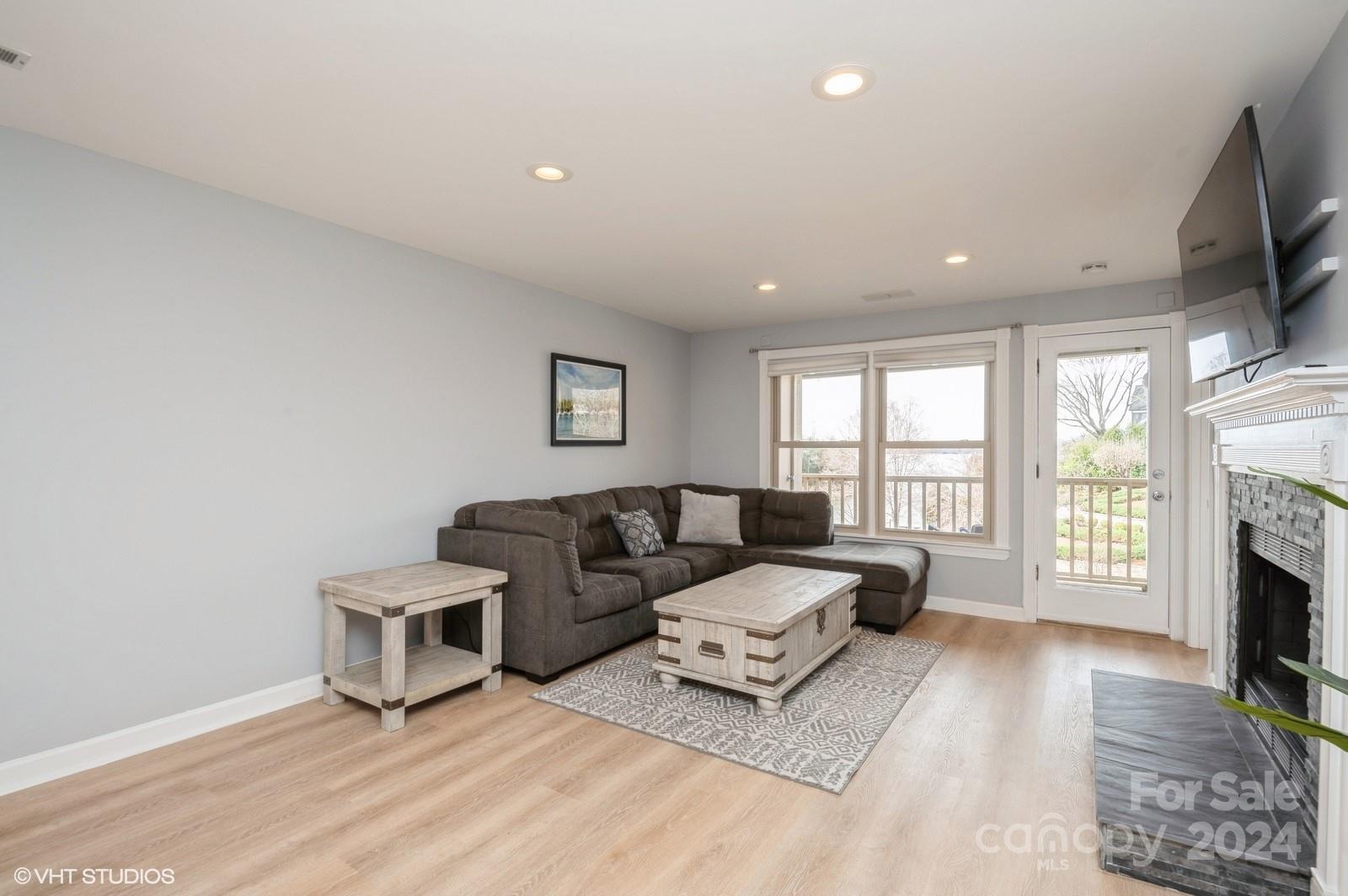 13822 Queens Harbor Road, Unit H Charlotte, NC 28278 - Photo 12 of 37 a living room with furniture flat screen tv and a fireplace