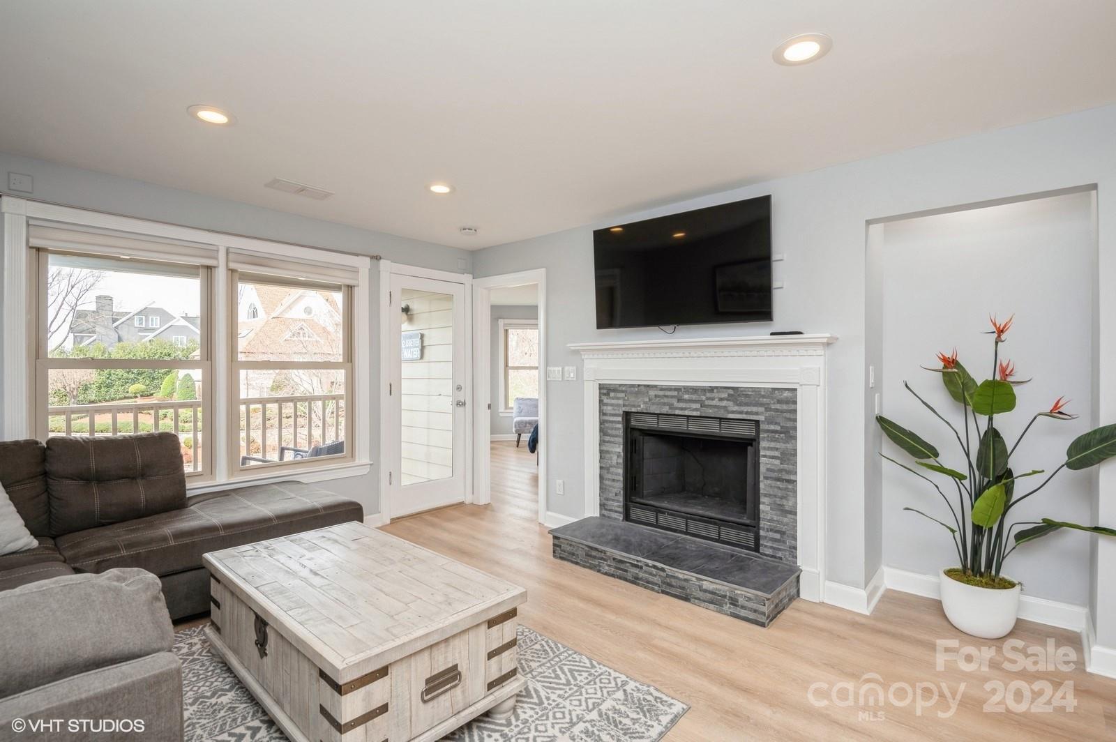 13822 Queens Harbor Road, Unit H Charlotte, NC 28278 - Photo 13 of 37 a living room with furniture a fireplace and a flat screen tv