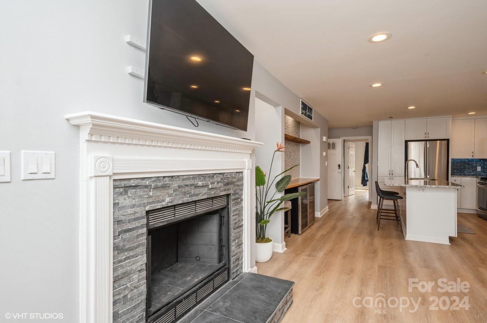 13822 Queens Harbor Road, Unit H Charlotte, NC 28278 - Photo 15 of 37 a living room with furniture a fireplace and kitchen view