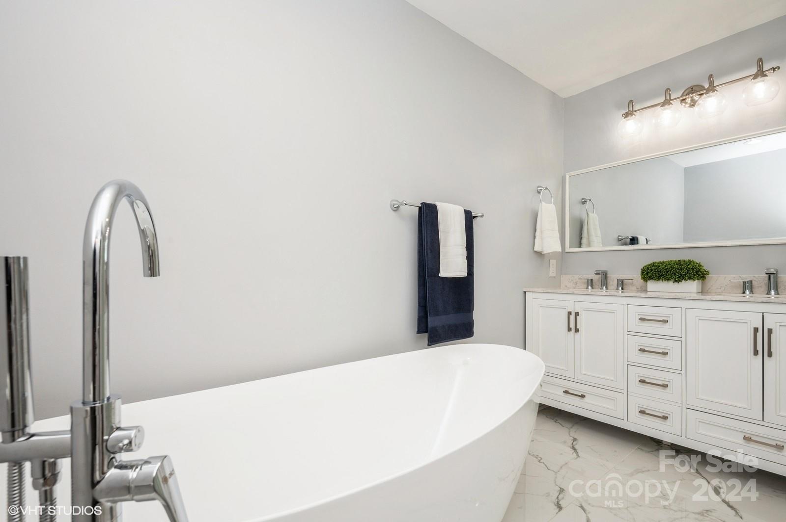13822 Queens Harbor Road, Unit H Charlotte, NC 28278 - Photo 19 of 37 a spacious bathroom with a bathtub sink and mirror