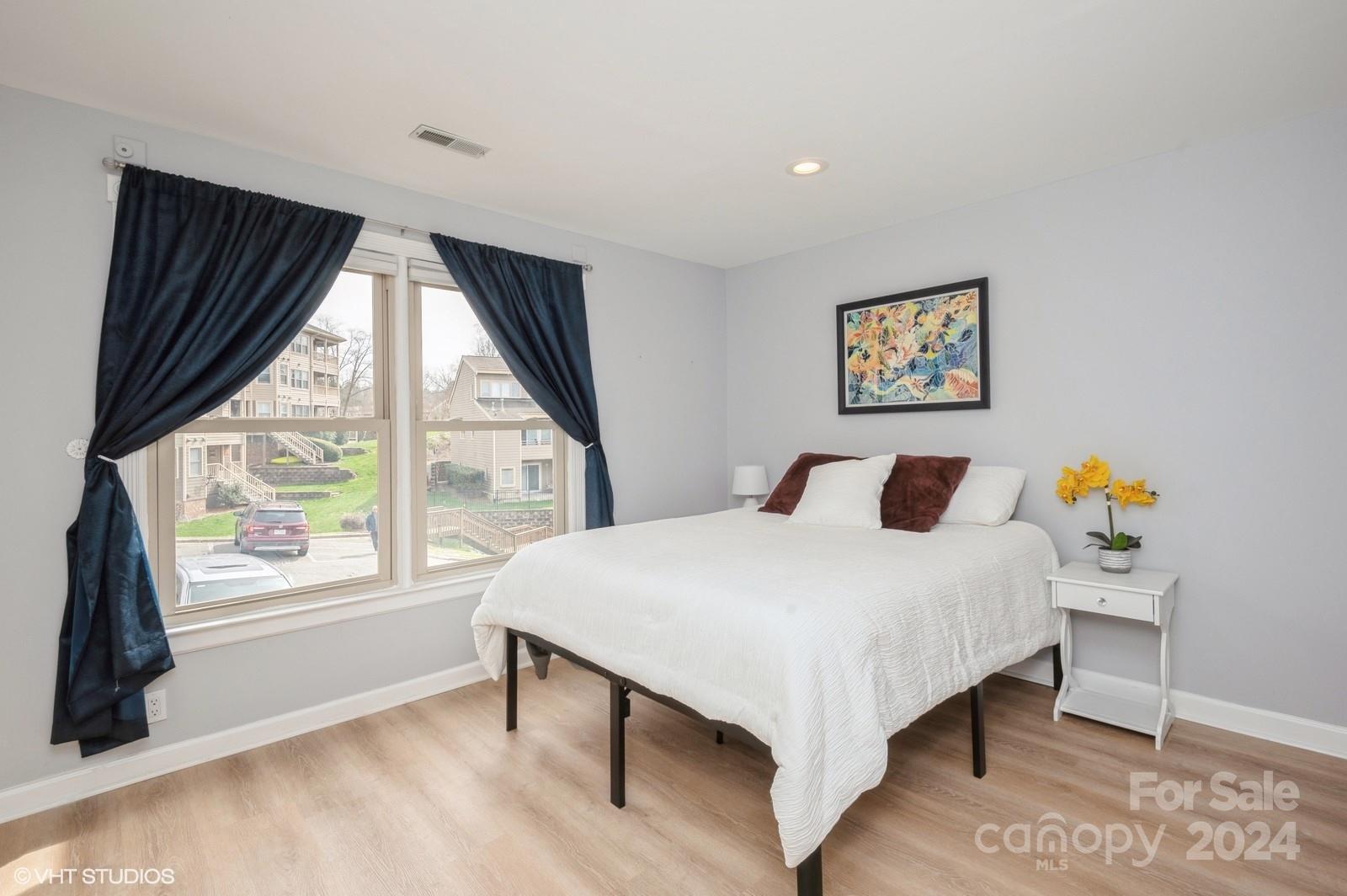13822 Queens Harbor Road, Unit H Charlotte, NC 28278 - Photo 26 of 37 a bedroom with a bed and a large window