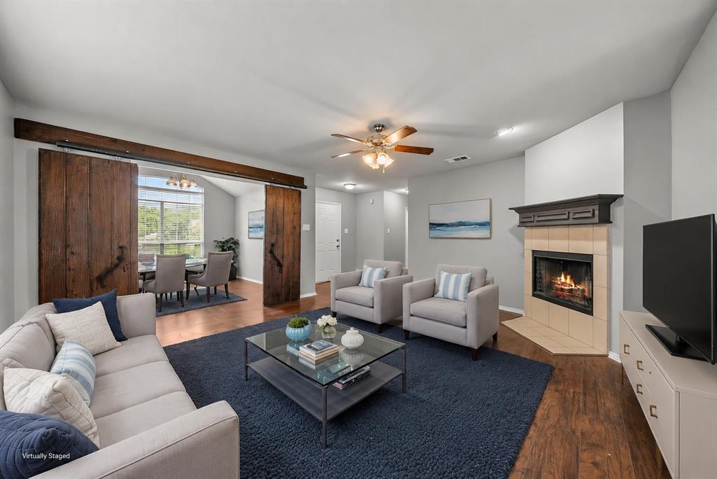834 Hazel's Way Anna, TX 75409 - Photo 4 of 21 Spacious living area featuring wood-finish flooring and a corner fireplace with a tiled surround