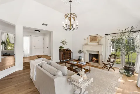 a living room with furniture a fireplace and a chandelier