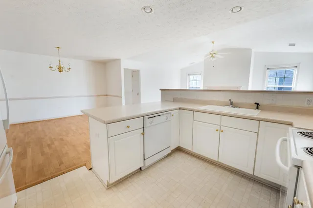 a kitchen with white cabinets and sink