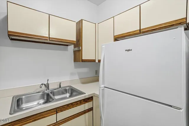 a kitchen with a cabinets and a refrigerator