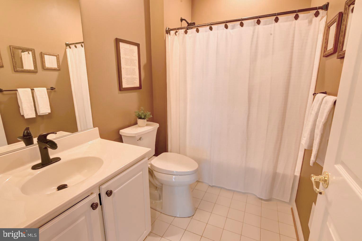 13170 Triple Crown Loop Gainesville, VA 20155 - Photo 41 of 71 a bathroom with a sink a toilet and shower curtain
