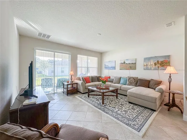 a living room with furniture potted plant and a large window