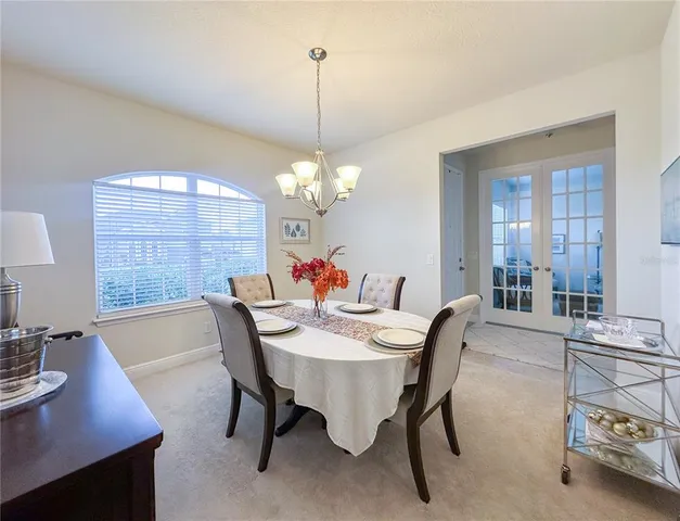 a dining room with furniture a chandelier and window