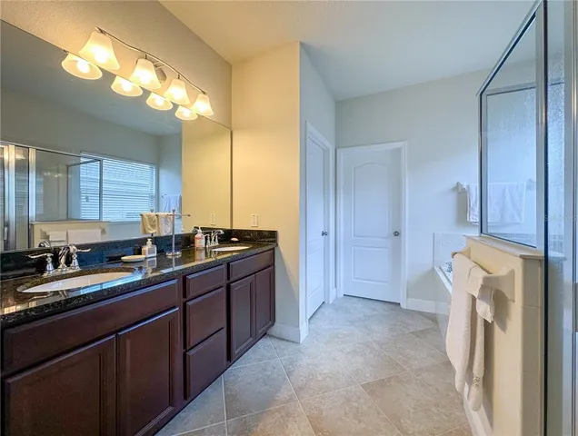 a large bathroom with a sink a mirror and a shower