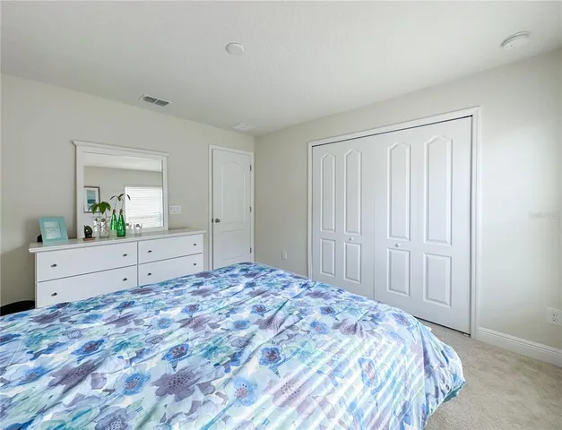 a view of a bedroom with wooden floor and cabinet