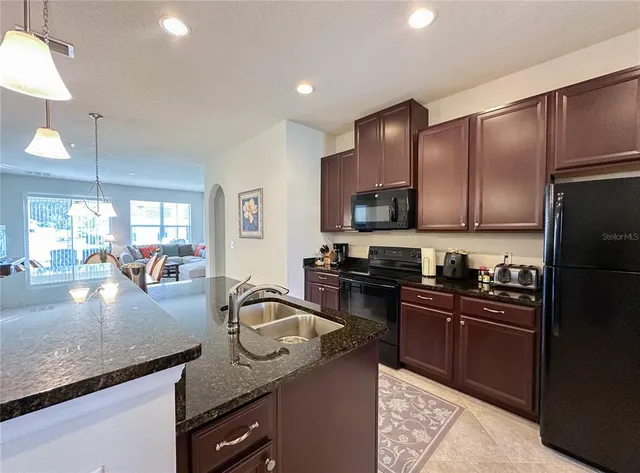 a kitchen with granite countertop stainless steel appliances and wooden cabinets