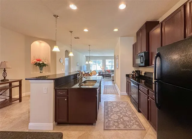 a kitchen with stainless steel appliances granite countertop a sink a stove and a refrigerator