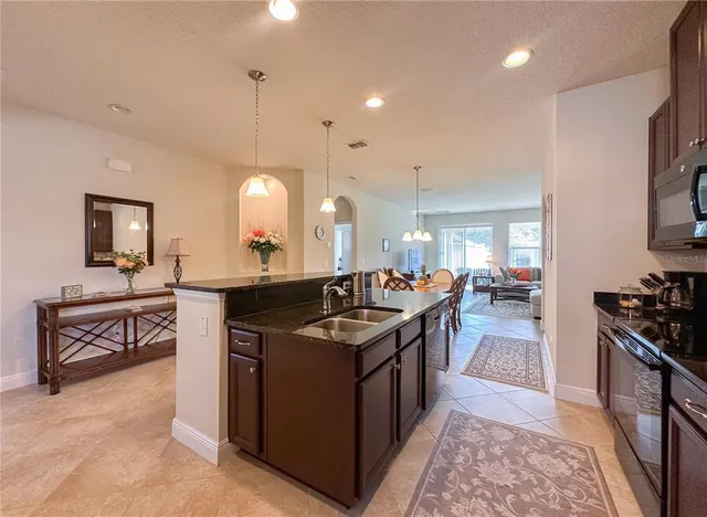 a kitchen with granite countertop a sink stove and cabinets