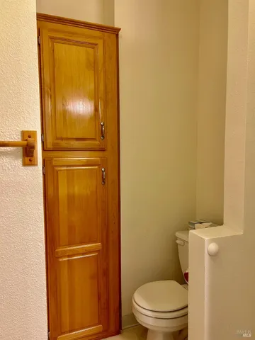 a bathroom with a granite countertop toilet and a sink