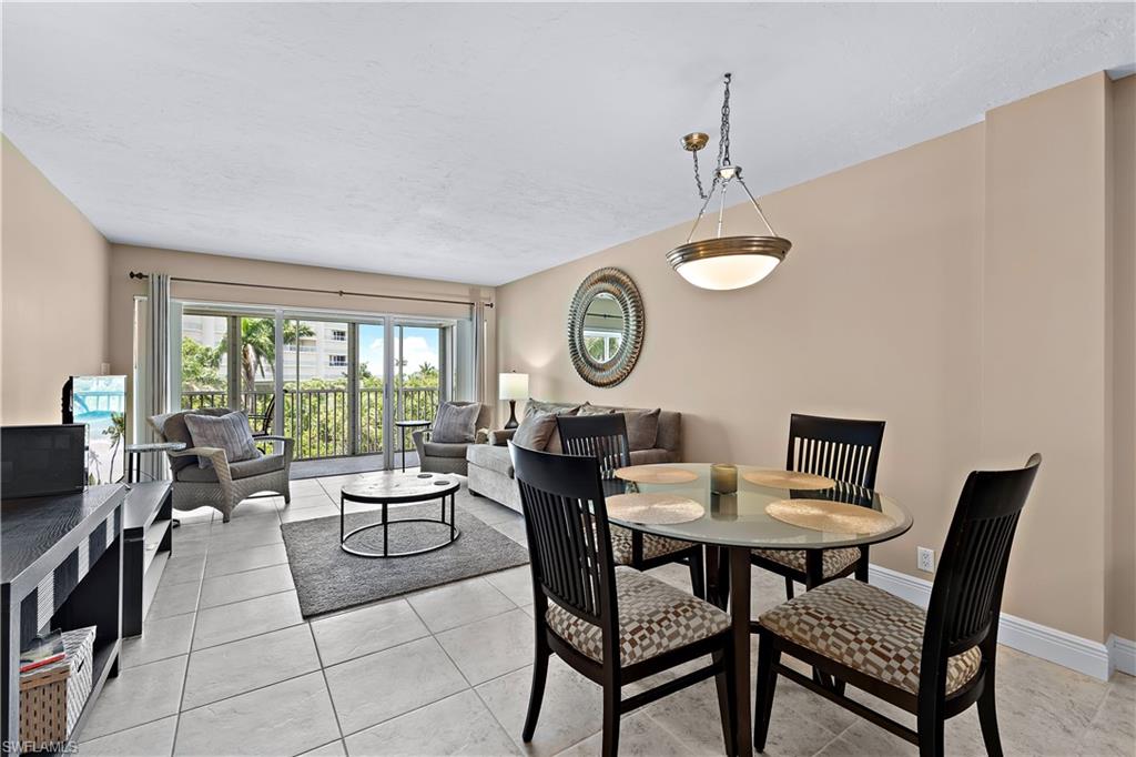 1 Bluebill Avenue, Unit 409 Naples, FL 34108 - Photo 1 of 17 a view of a dining room with furniture and a large window